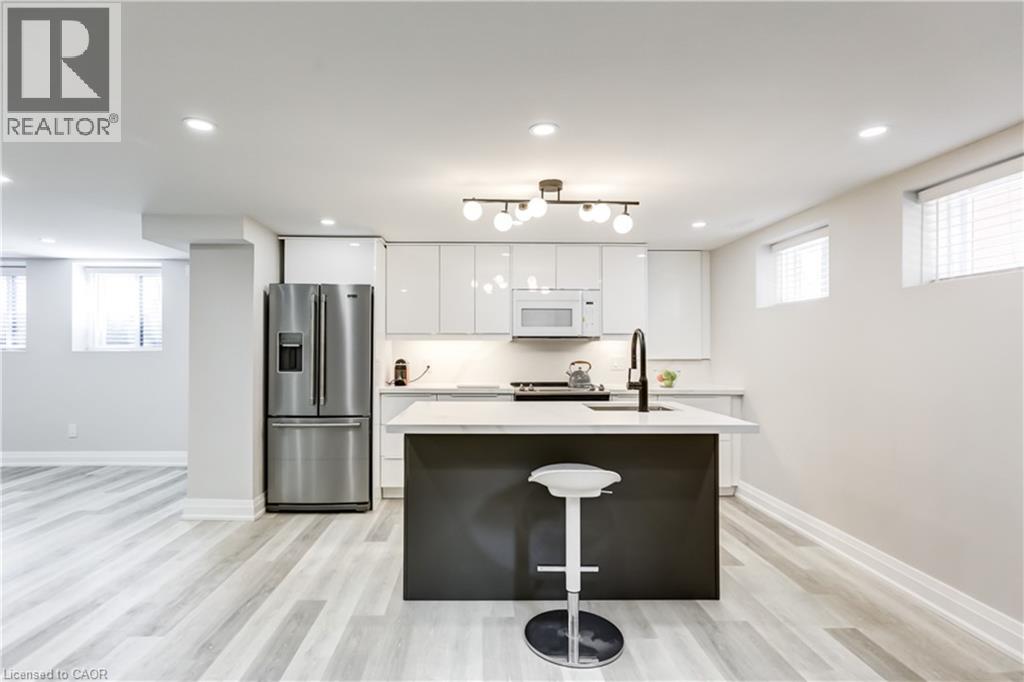 A modern kitchen with a bar stool in front of the island.