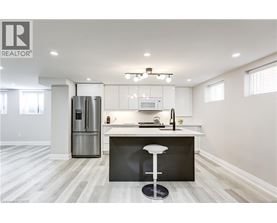 A modern kitchen with a bar stool in front of the island.