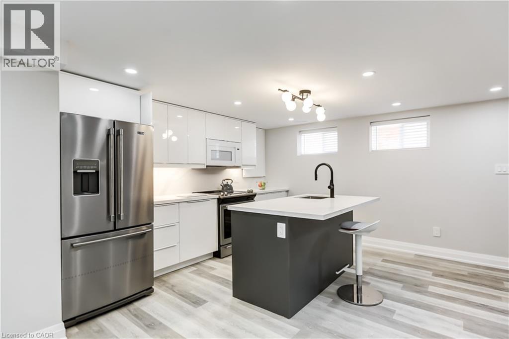 A modern kitchen with a refrigerator, stove, and island.