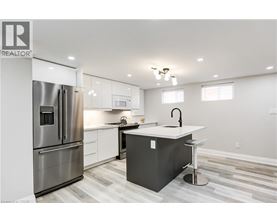 A modern kitchen with a refrigerator, stove, and island.
