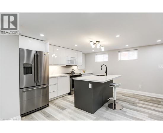 A modern kitchen with a refrigerator, stove, and island.