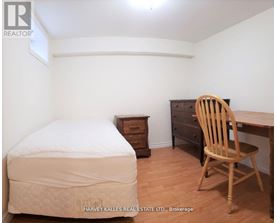 A bedroom with a bed, chair, and desk.
