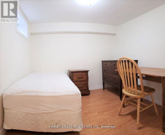 A bedroom with a bed, chair, and desk.