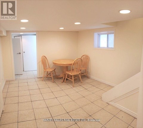 A dining room with a table and chairs.