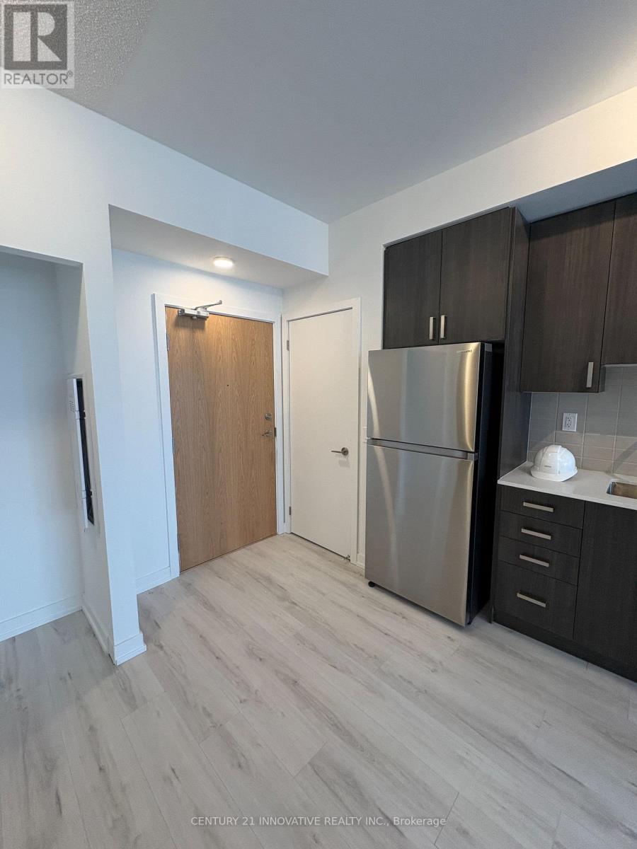 A modern kitchen with a refrigerator, cabinets, and a countertop.
