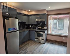 A kitchen with a refrigerator, oven, and sink.