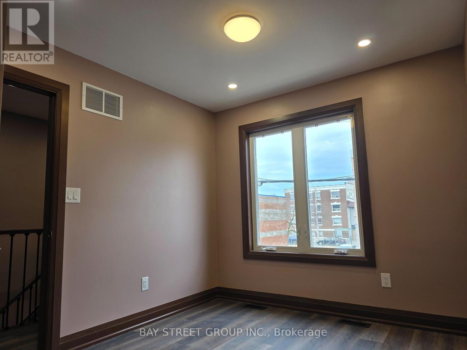 A room with a window showing a view of a building outside.