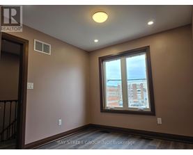 A room with a window showing a view of a building outside.