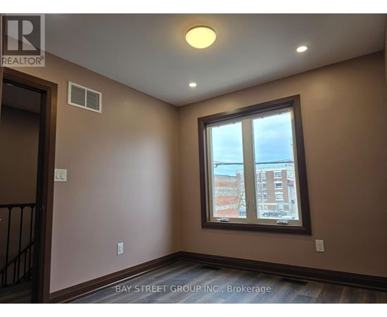 A room with a window showing a view of a building outside.