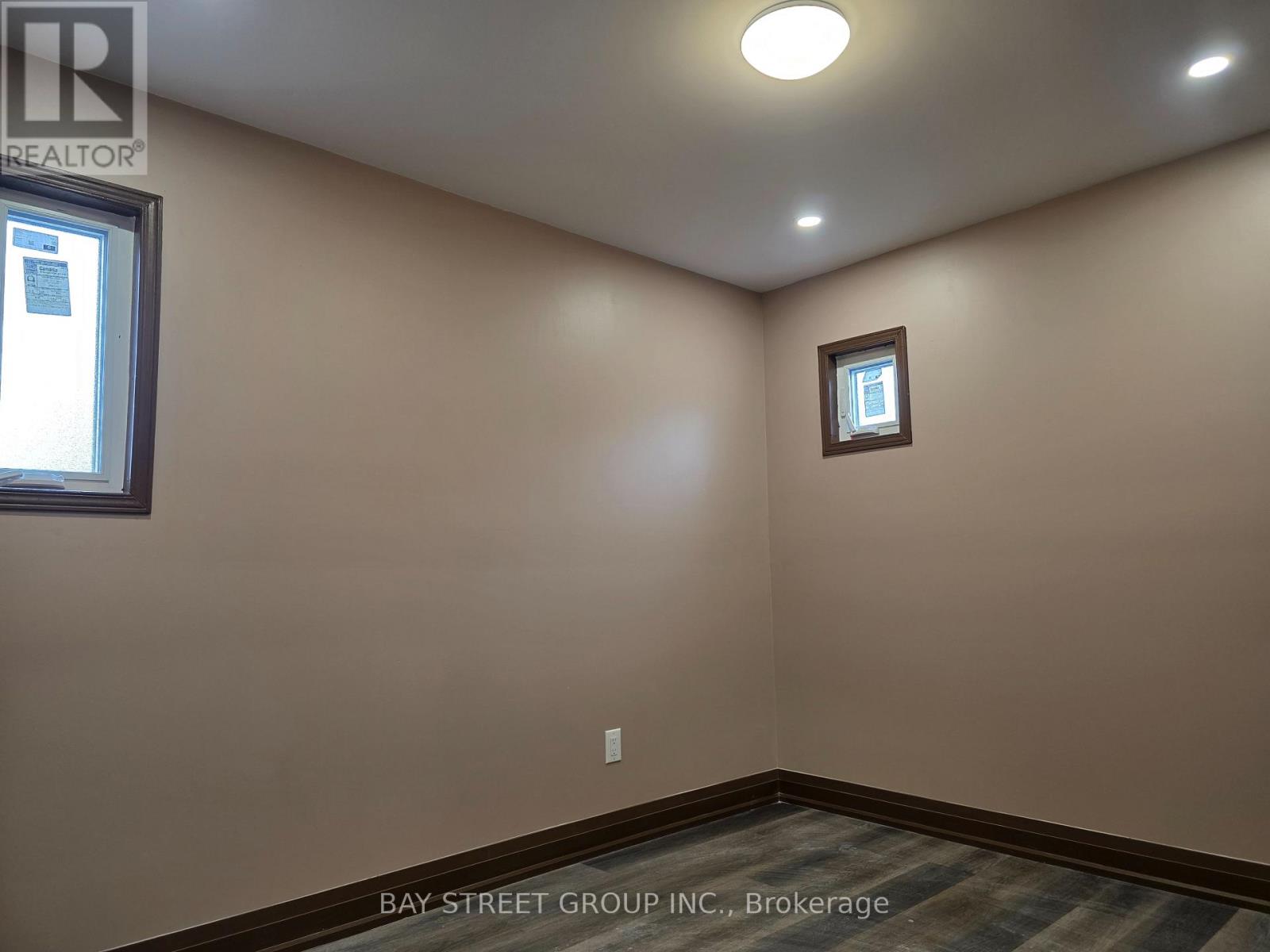 A room with a window and a small picture frame on the wall.