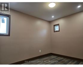 A room with a window and a small picture frame on the wall.