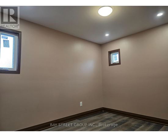 A room with a window and a small picture frame on the wall.