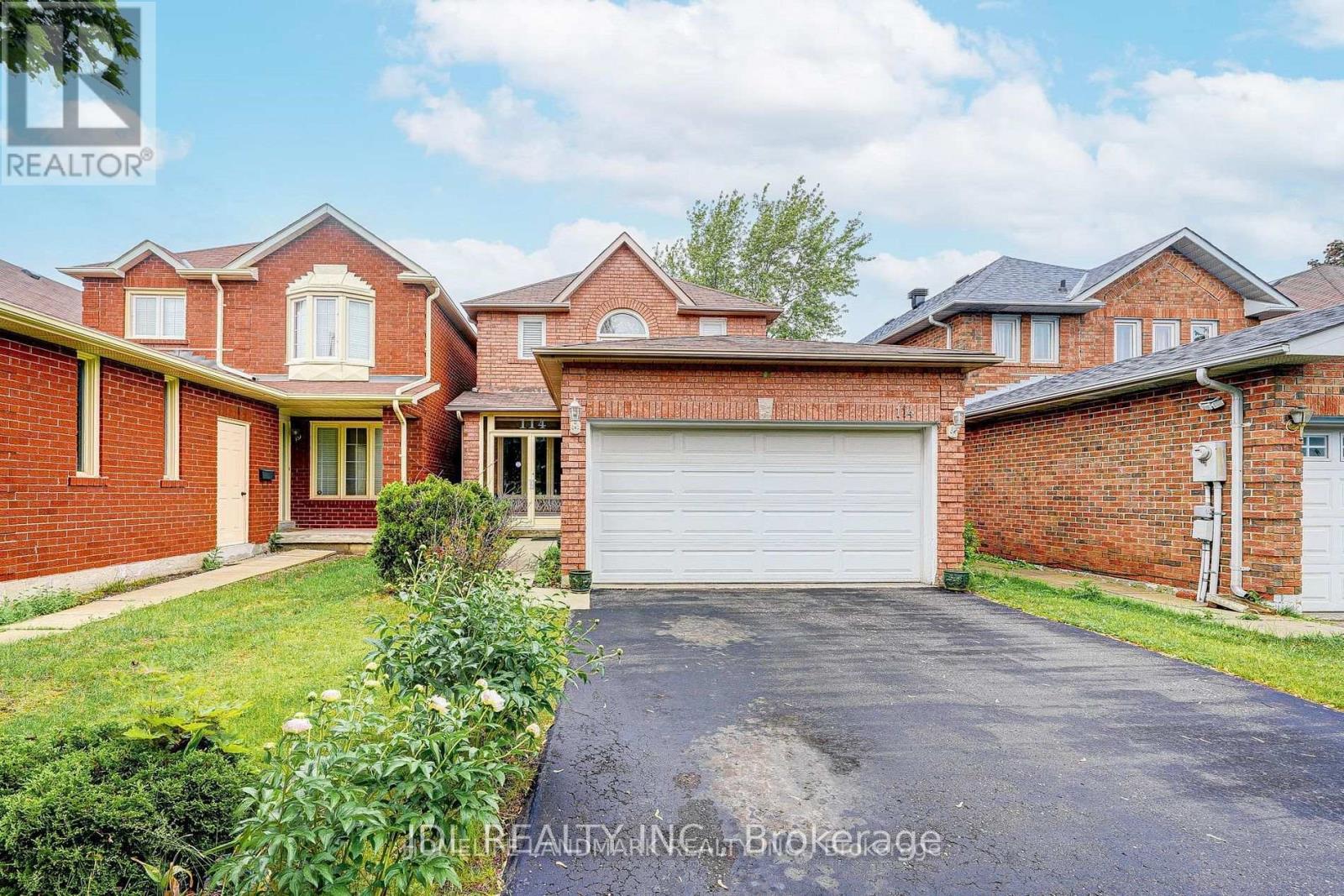 A red brick house with a white garage door.