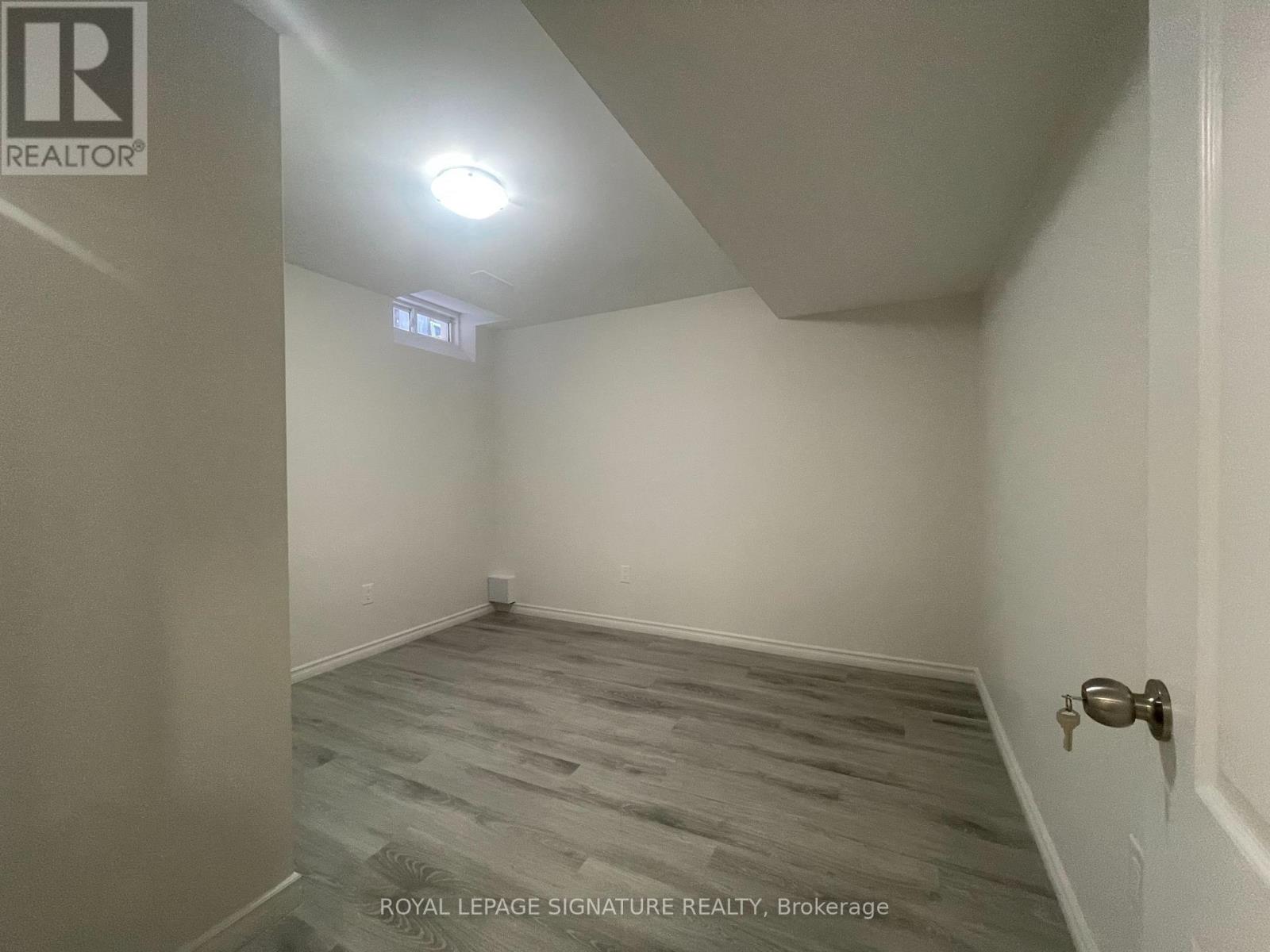 A room with a wooden floor and a door on the right side.