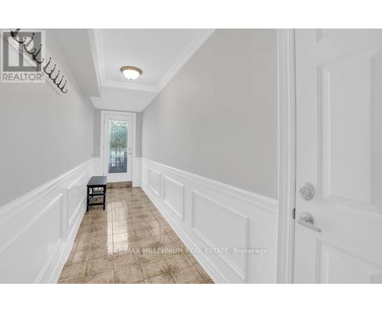 A hallway with a bench and a door.