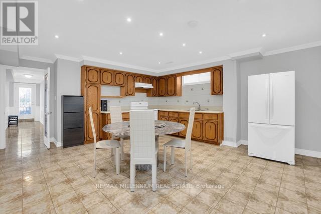 A well-lit kitchen with a dining table and chairs in the foreground.