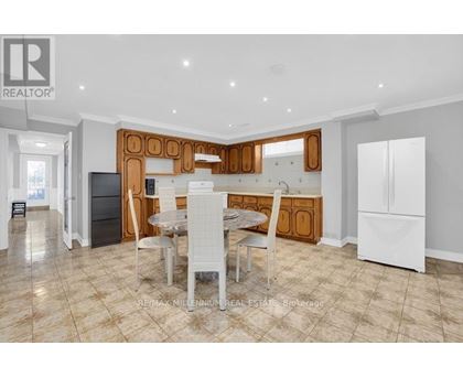 A well-lit kitchen with a dining table and chairs in the foreground.
