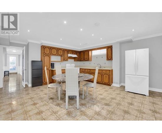 A well-lit kitchen with a dining table and chairs in the foreground.