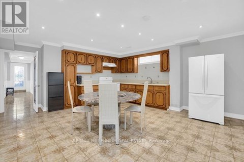 A well-lit kitchen with a dining table and chairs in the foreground.