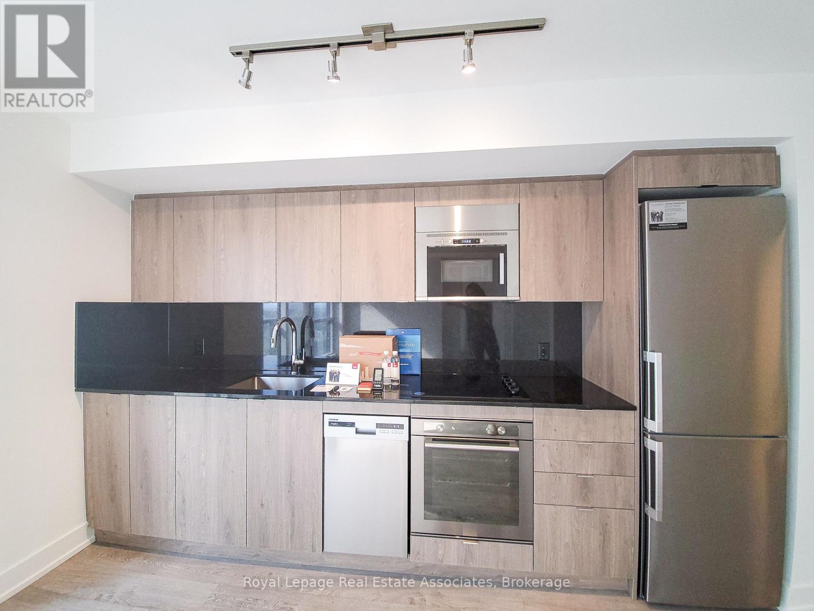 A modern kitchen with a stainless steel refrigerator and oven.