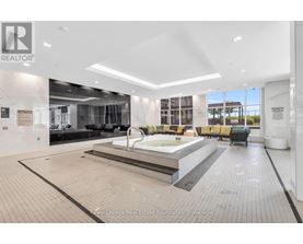 A large, modern indoor swimming pool area with a hot tub and seating area.