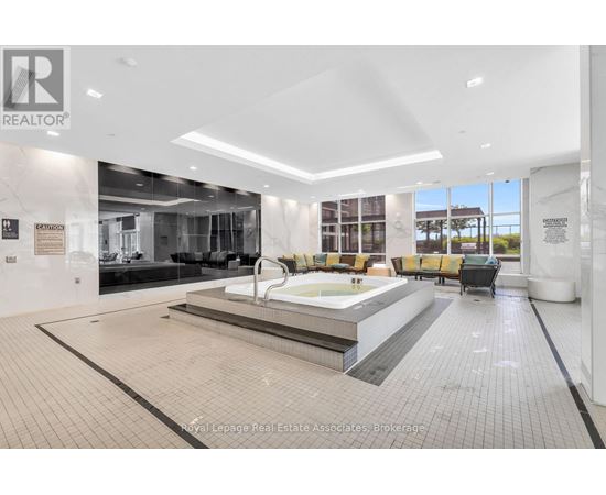 A large, modern indoor swimming pool area with a hot tub and seating area.
