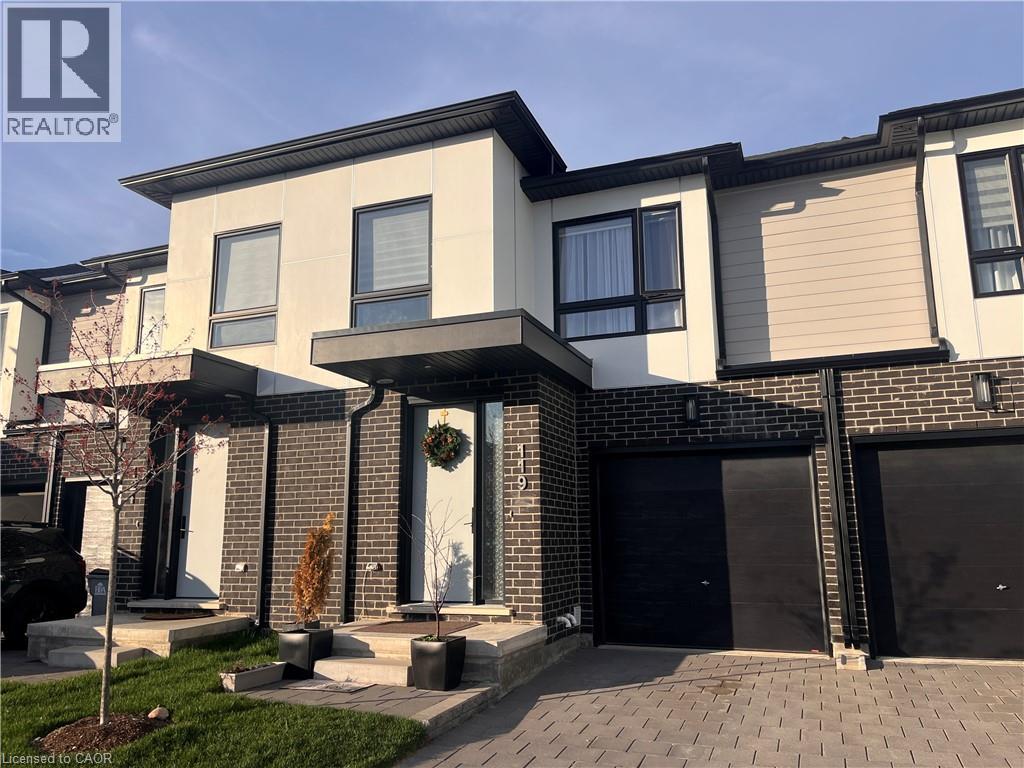 A modern house with a black garage door is for sale.