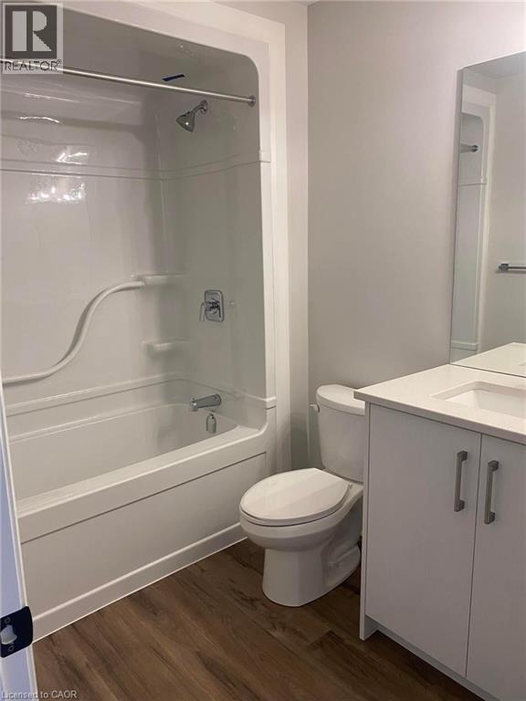 A white bathroom with a toilet, sink, and bathtub.