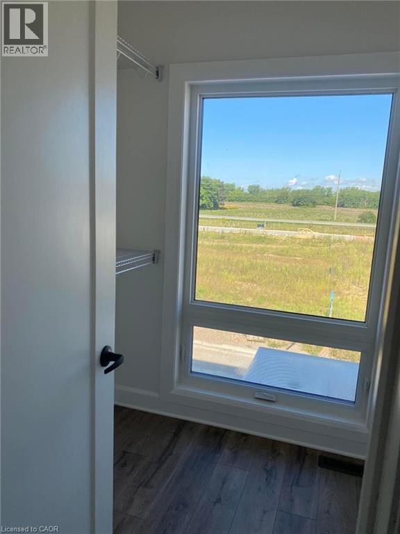 A window with a view of a field and a road.
