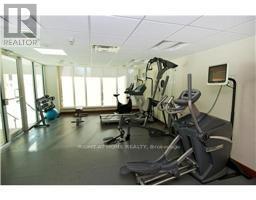 A gym with a row of treadmilers and elliptical machines.