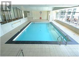A large indoor swimming pool with a blue tiled bottom.