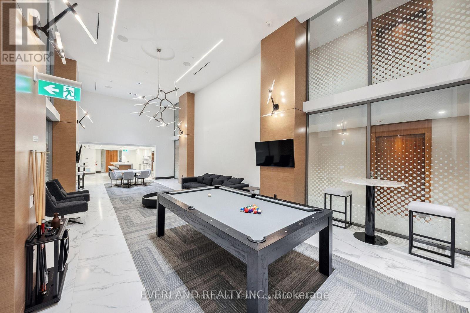 A pool table is in the middle of a room with a glass wall.