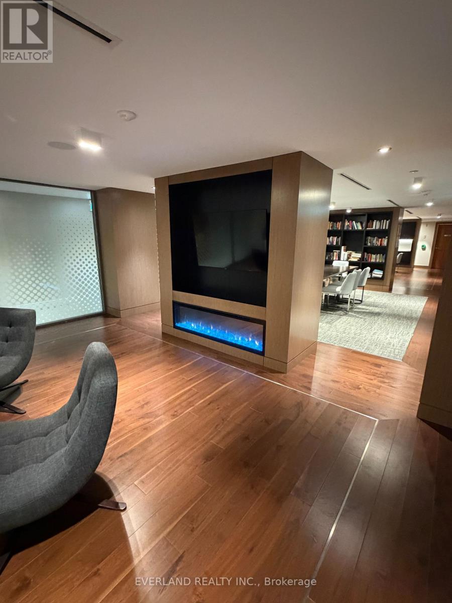 A modern living room with a grey chair and a large television.