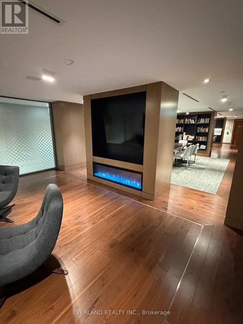 A modern living room with a grey chair and a large television.