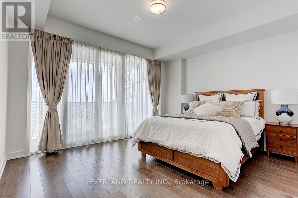A bedroom with a large bed, wooden furniture, and a window with curtains.