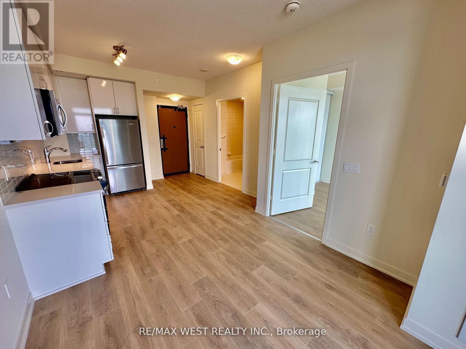 A kitchen with white cabinets and a refrigerator is shown in this image.