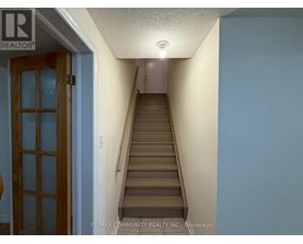 A hallway with a staircase leading to the second floor.