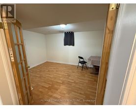 A room with wooden flooring and a chair.