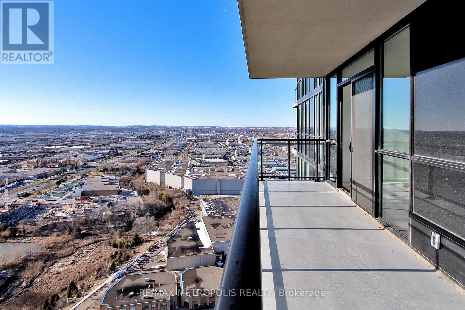 A balcony overlooks a cityscape from a high-rise building.