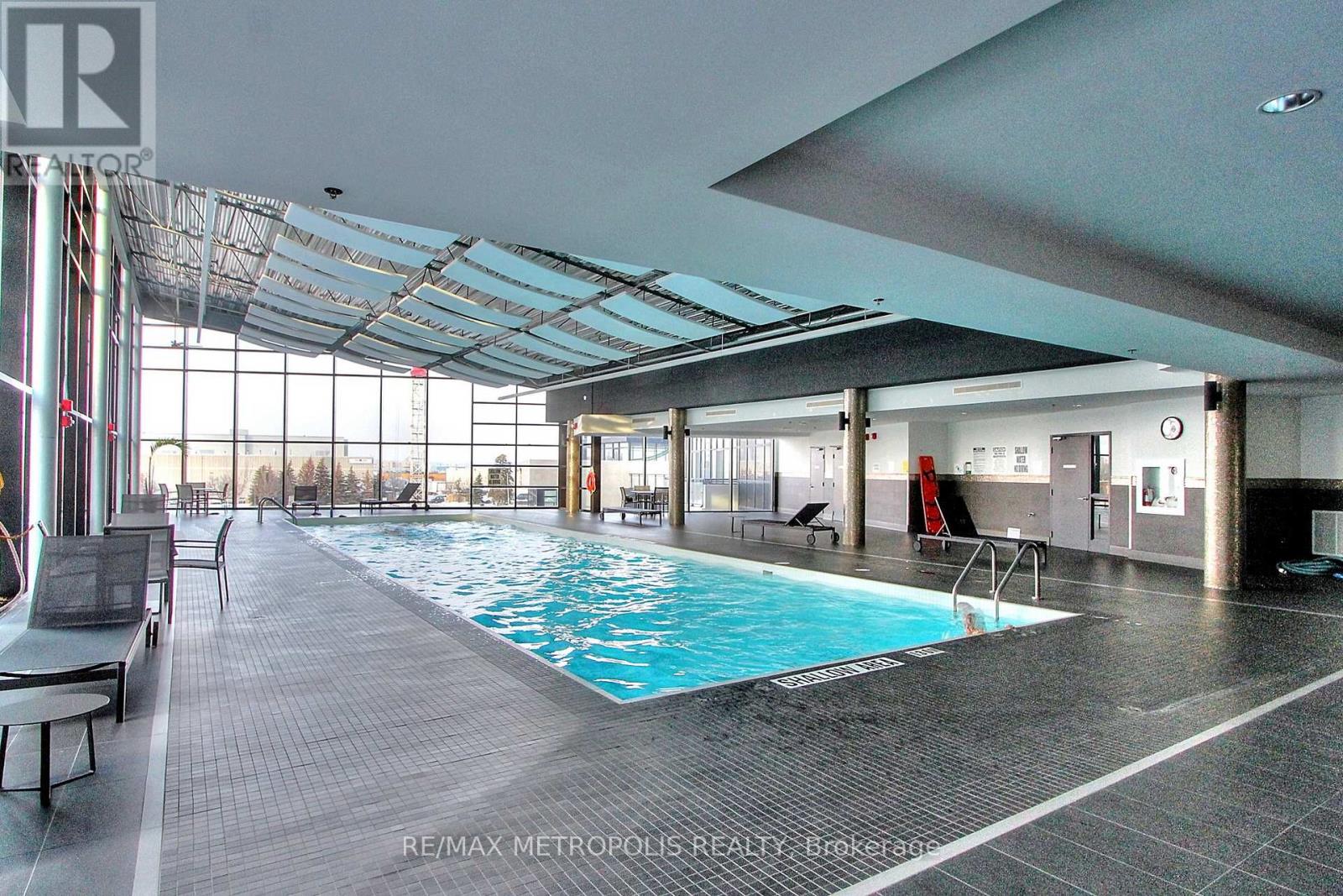 A large indoor swimming pool with a glass ceiling.
