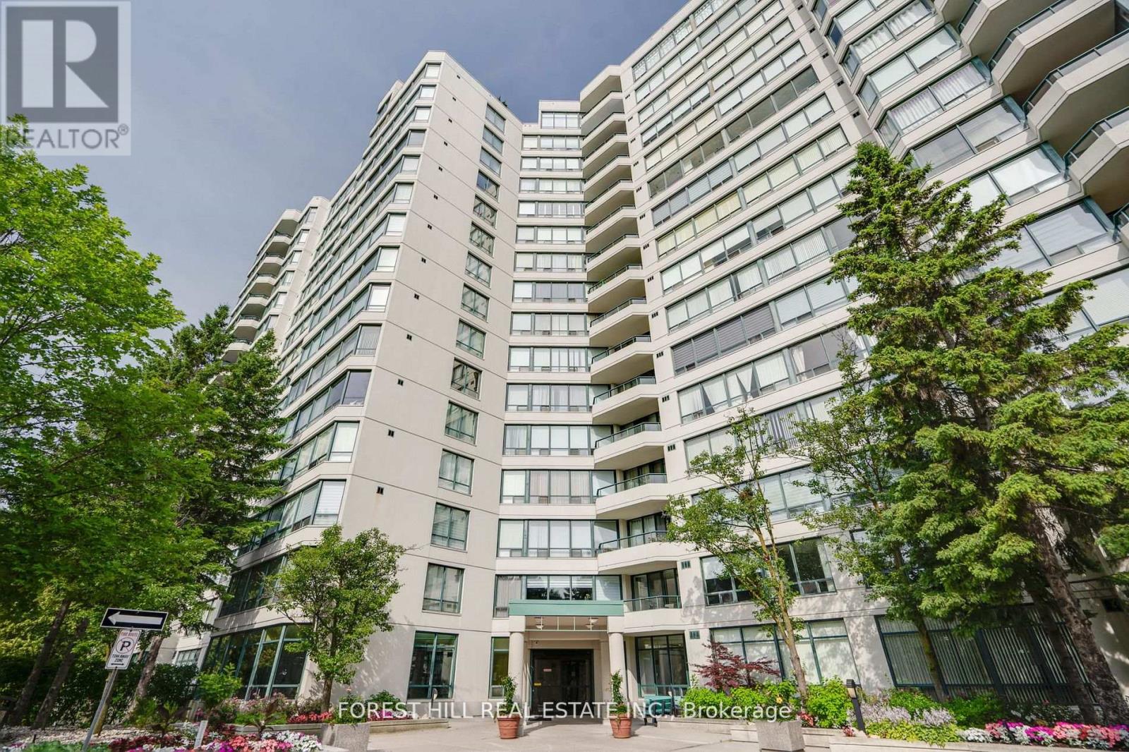 A tall residential building with balconies and a front entrance.