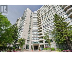 A tall residential building with balconies and a front entrance.