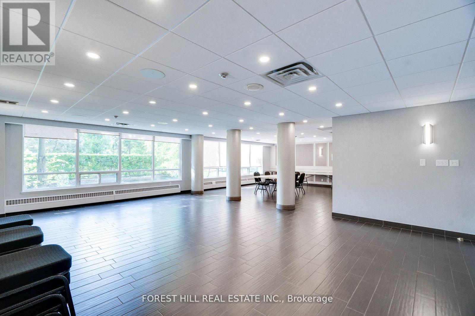 A spacious office room with a view of trees outside the windows.