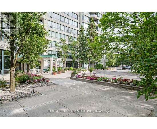 A courtyard with a lot of greenery and a building in the background.