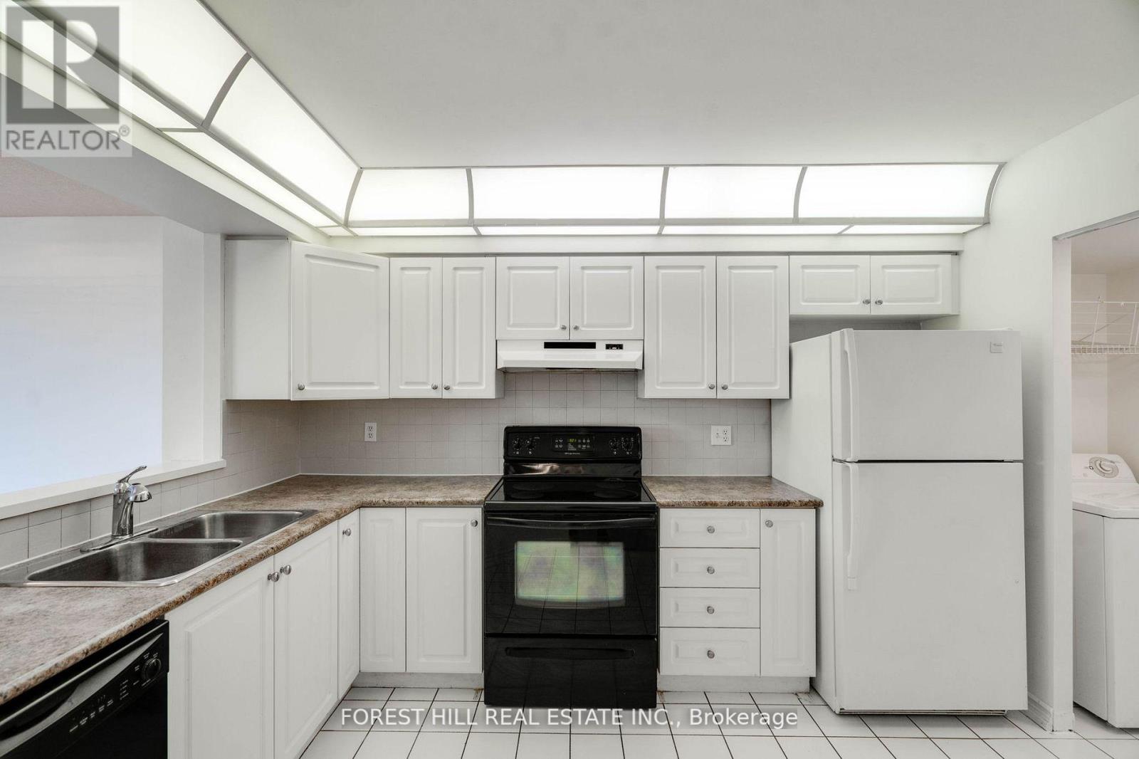 A kitchen with white cabinets and appliances.