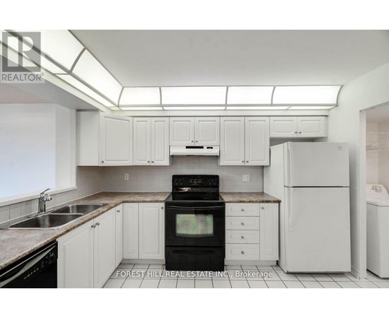 A kitchen with white cabinets and appliances.
