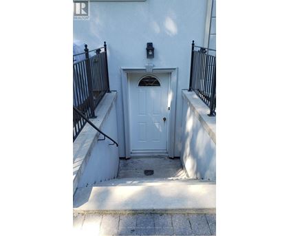 A white door with a black railing on either side.