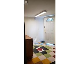 A white door is in a room with a checkered floor.