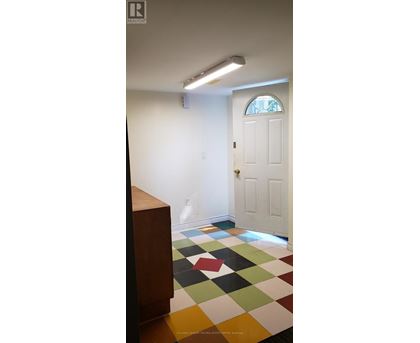 A white door is in a room with a checkered floor.