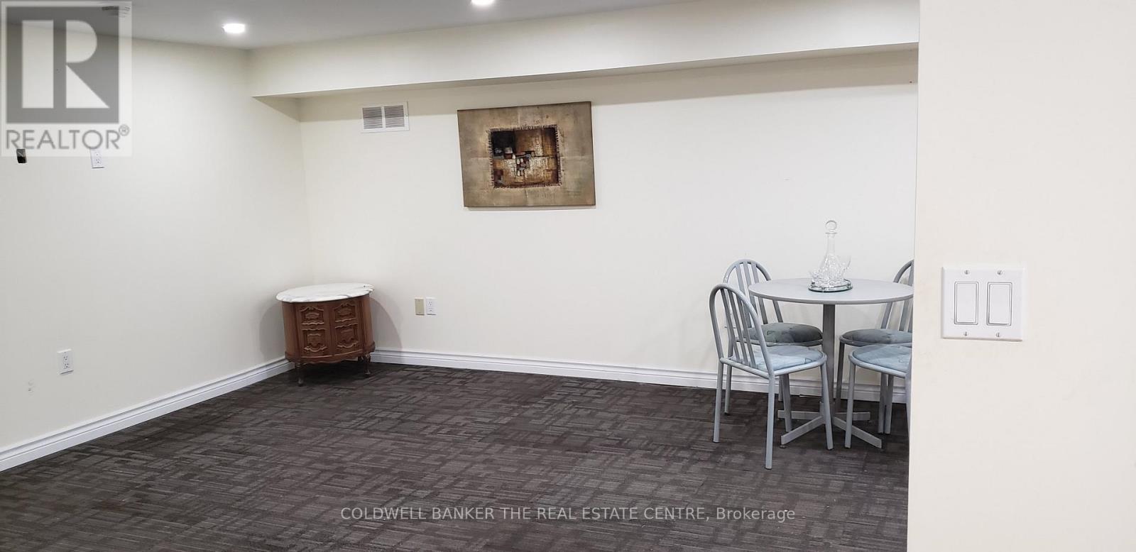 A dining room with a table and chairs.